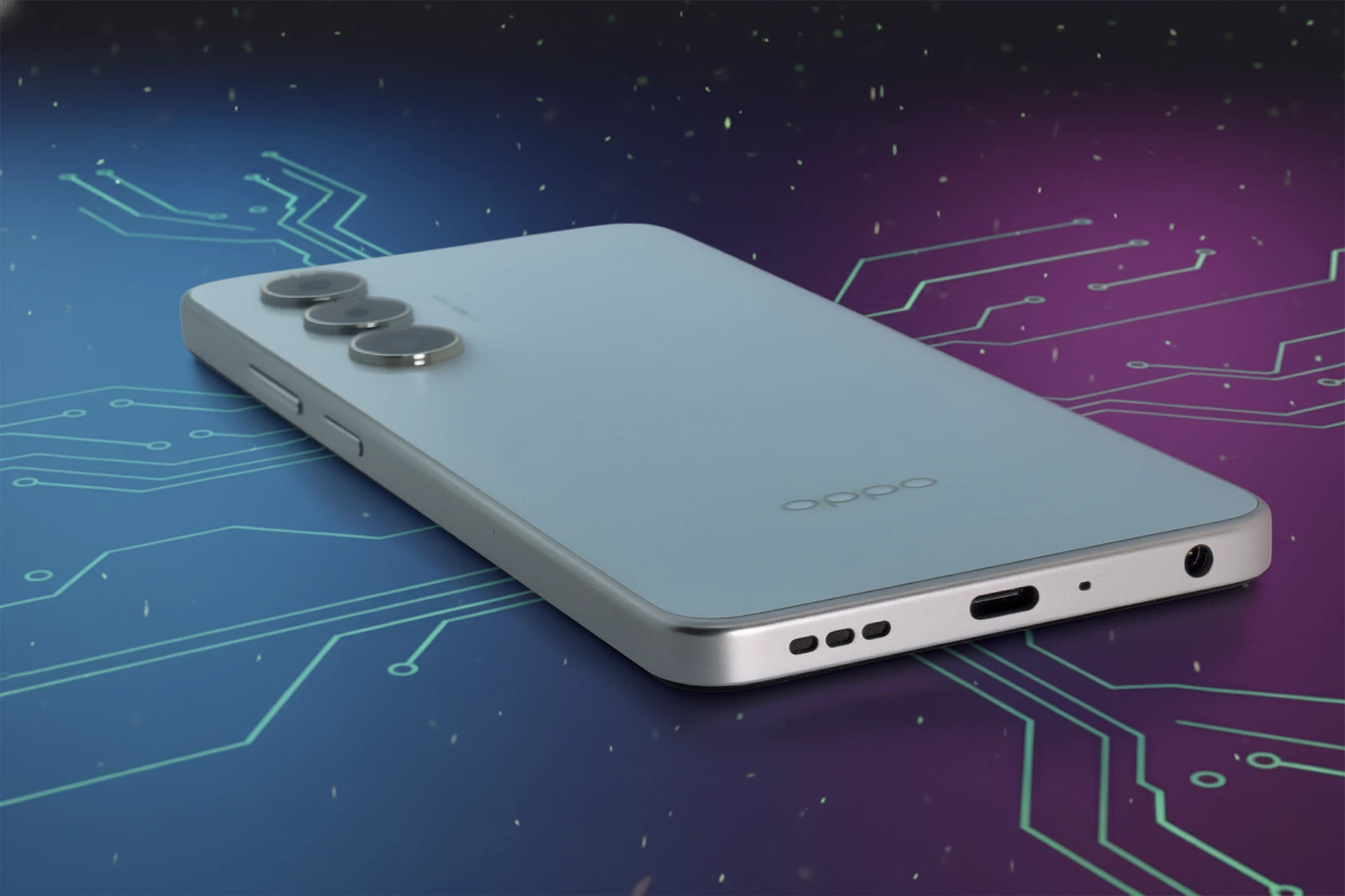 青と紫の回路図のような未来的な背景に置かれたOPPO A5 5Gの斜め下からのクローズアップ。底面には3.5mmイヤホンジャック、USB Type-Cポート、スピーカー穴が見える。