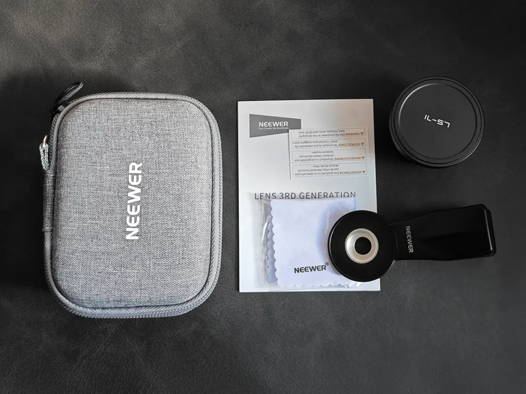 NEEWER LS-71 58mm望遠レンズの同梱品一式。専用セミハードケース、レンズ本体、取付用クリップ、クリーニングクロス、取扱説明書の俯瞰写真。