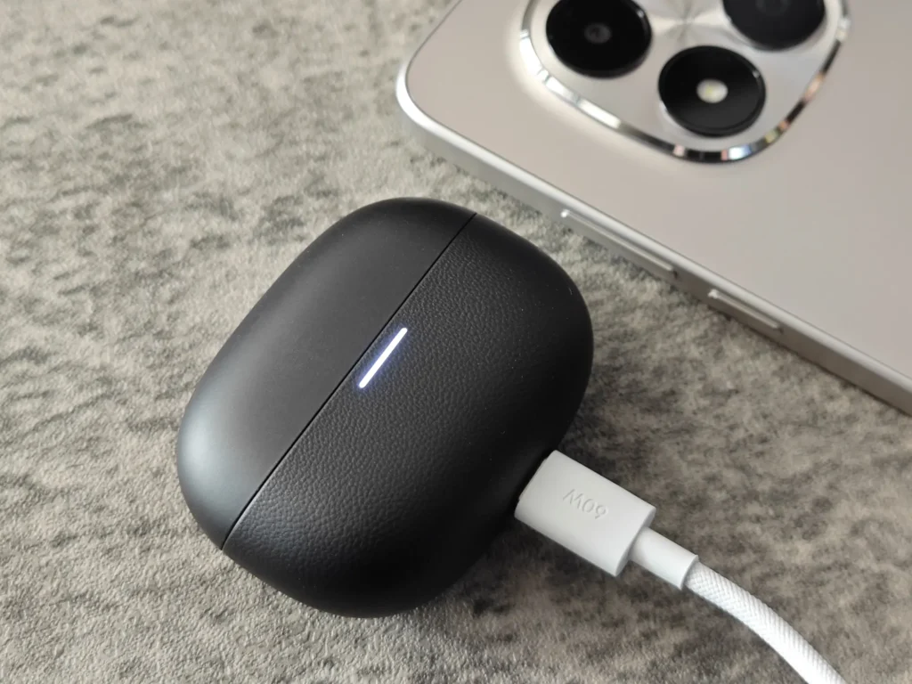 Redmi Note 15 Pro 5Gのカメラユニット横でRedmi Buds 5 Proのケースを充電する様子