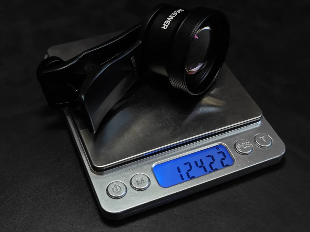 NEEWER 58mm望遠レンズと取付クリップを合わせた総重量の計測（約124.22g）。POCO X7 Pro装着時の携行性の目安。