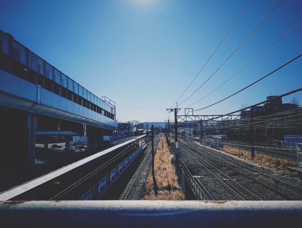 Nothing Phone (3a) Liteの作例。駅と線路を逆光気味に撮影し、フィルム風LUTでノスタルジックに仕上げた写真