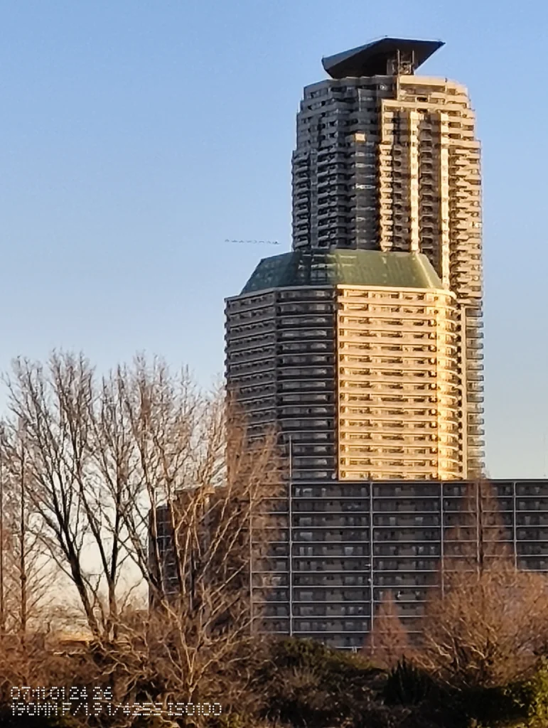 Nothing Phone (3a) Lite/カメラ:メイン(広角)約7.9倍ズーム/焦点距離:190mm相当/内容:高層ビル上部を大きく拡大し、窓の反復と陰影の境界が目立つ構図で、背景の空がシンプルに支える