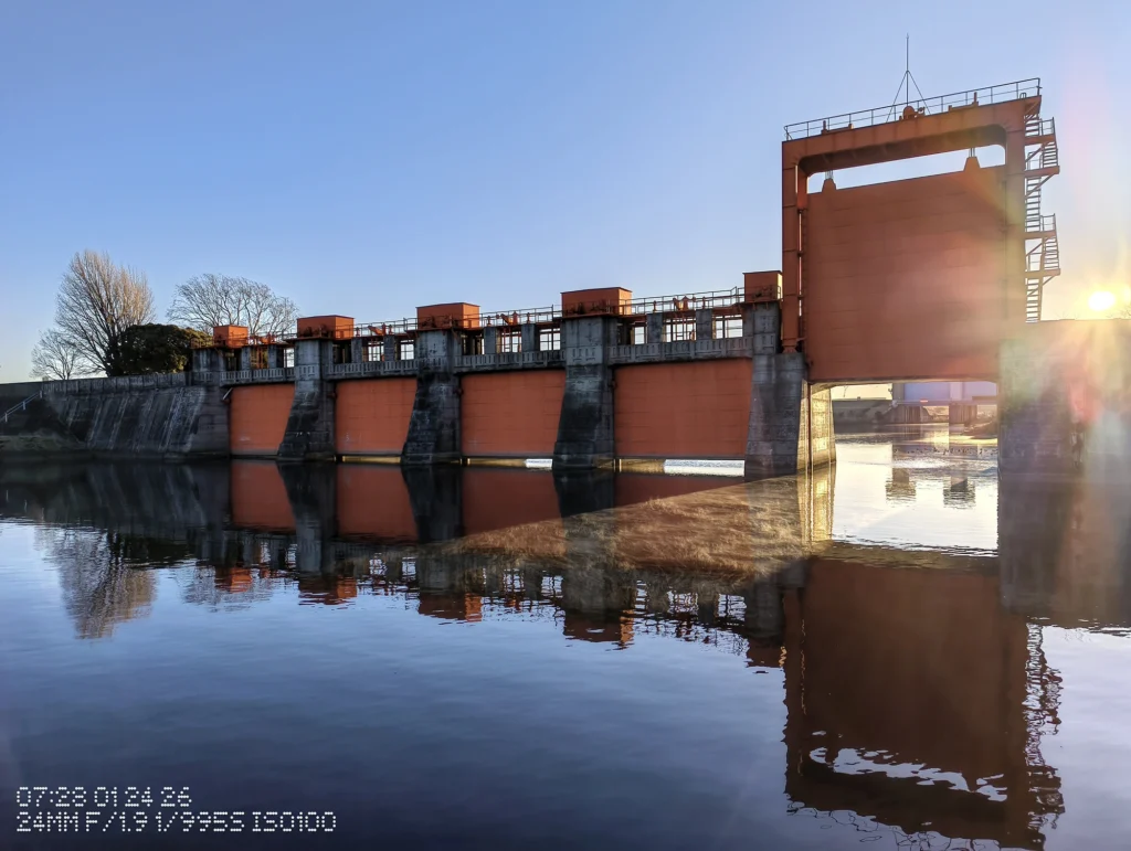 Nothing Phone (3a) Liteで撮影した、水面が鏡のように反射する堰と護岸の風景