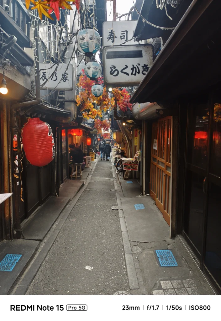 Redmi Note 15 Pro 5G メインカメラ作例。新宿「思い出横丁」の狭い路地裏。23mm f/1.7による赤提灯と秋の装飾のスナップ描写。