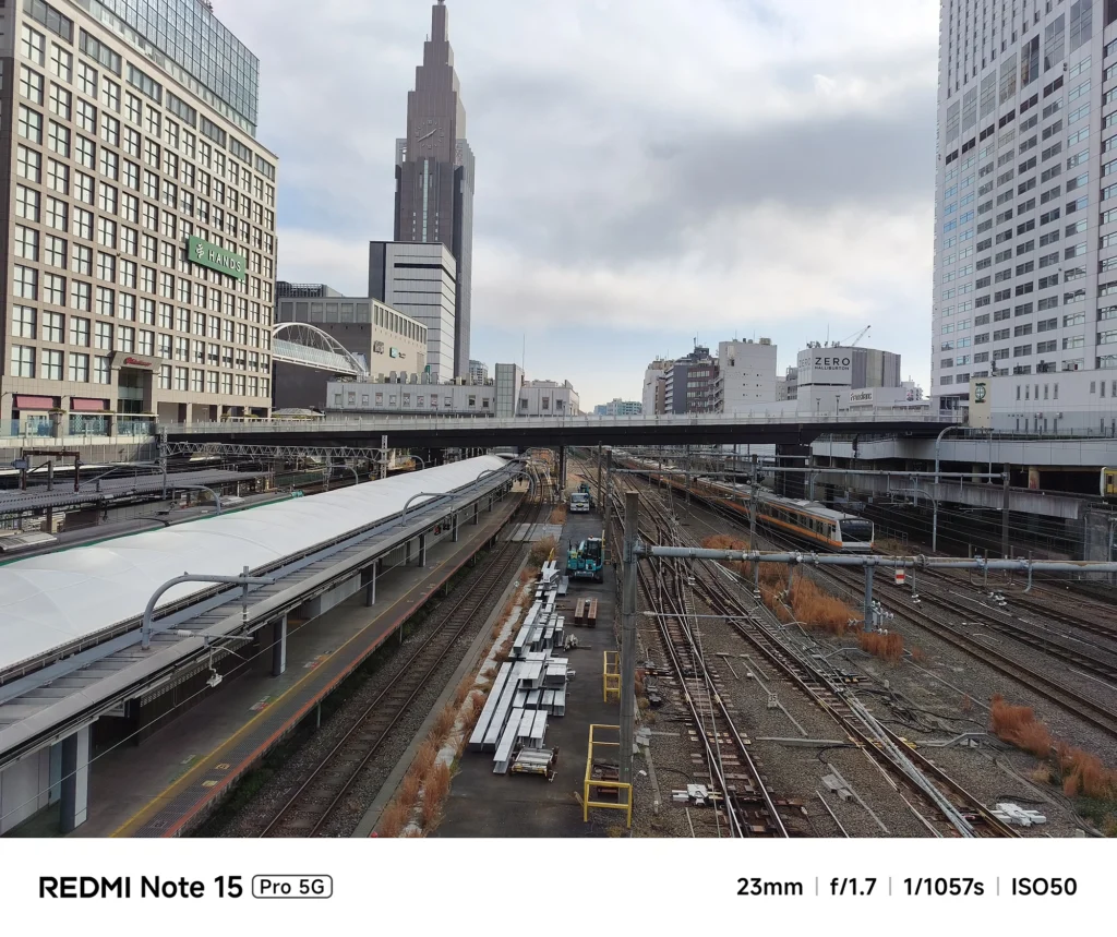 Redmi Note 15 Pro 5G メインカメラによる風景写真。23mmの標準的な画角で捉えた鉄道インフラと都会のビル群。