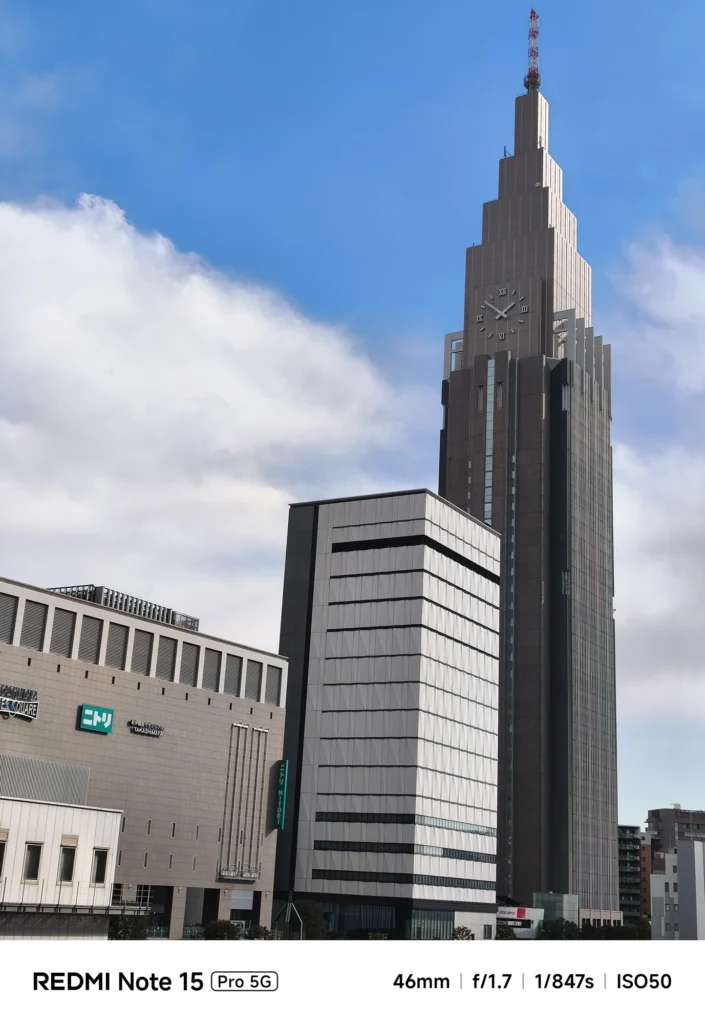 Redmi Note 15 Pro 5G 46mm相当で撮影したドコモ代々木ビル。青空を背景にした時計塔のディテールと色の再現性。