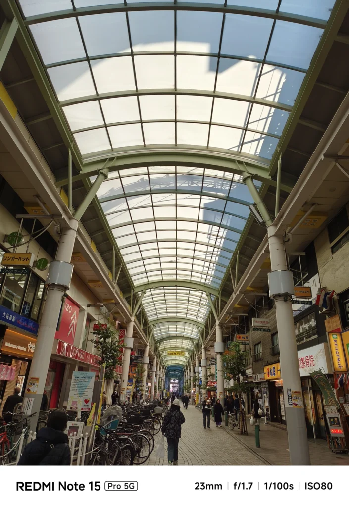 Redmi Note 15 Pro 5G メインカメラによる商店街アーケードのショット。23mmの画角で歪み少なく捉えた巨大なガラス天井。
