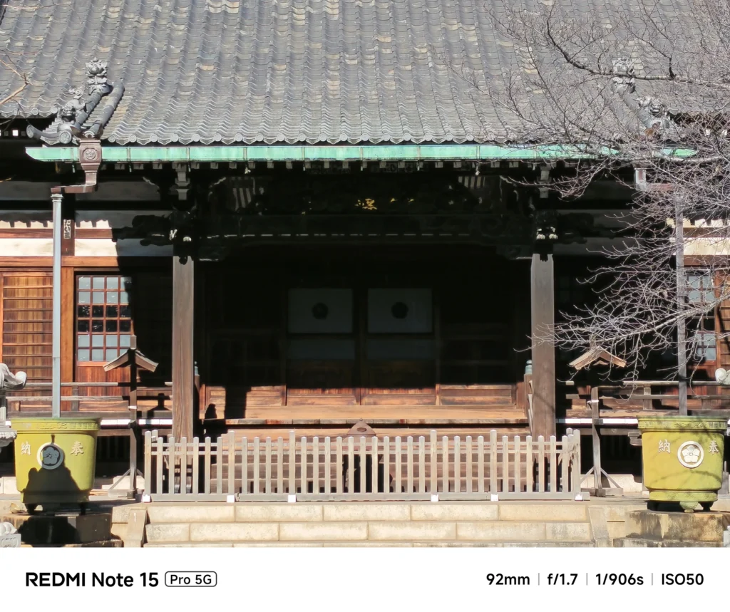 寺院の本堂の向拝(ごはい)部分。精緻な木彫りや屋根瓦の重なりを捉えたディテール写真。Redmi Note 15 Pro 5G(92mm)で撮影。