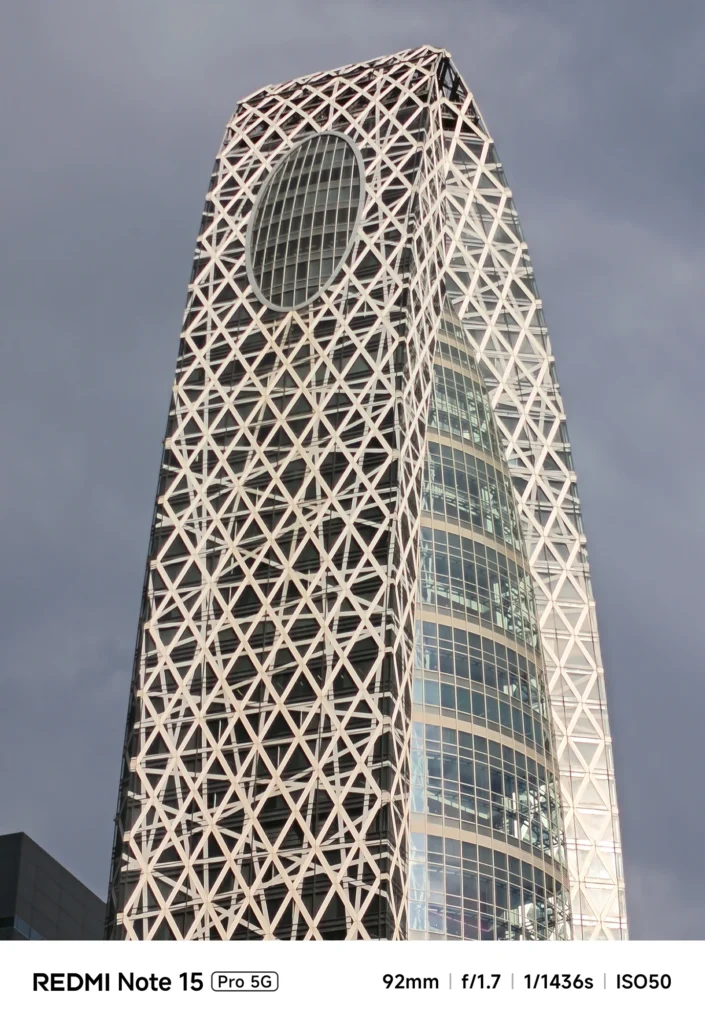 モード学園コクーンタワーの網目状の外装を強調した建築写真。幾何学的な構造美。Redmi Note 15 Pro 5G(92mm)で撮影。