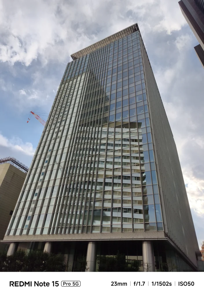 Redmi Note 15 Pro 5G メインカメラ作例。ガラス張りの高層ビルとクレーンを23mmの画角でクリアに捉えた解像感のテスト。