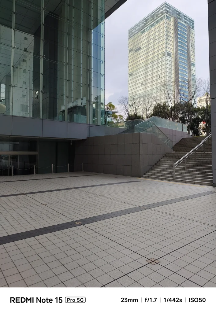 Redmi Note 15 Pro 5G メインカメラによる建築スナップ。ガラスのエントランスと広場を23mm f/1.7で歪み少なく描写。