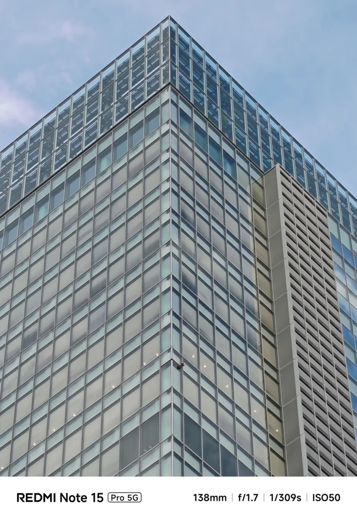ビル最上部の構造をさらに引き寄せた描写。ガラス越しの内部構造。Redmi Note 15 Pro 5G(138mm/6倍)で撮影。