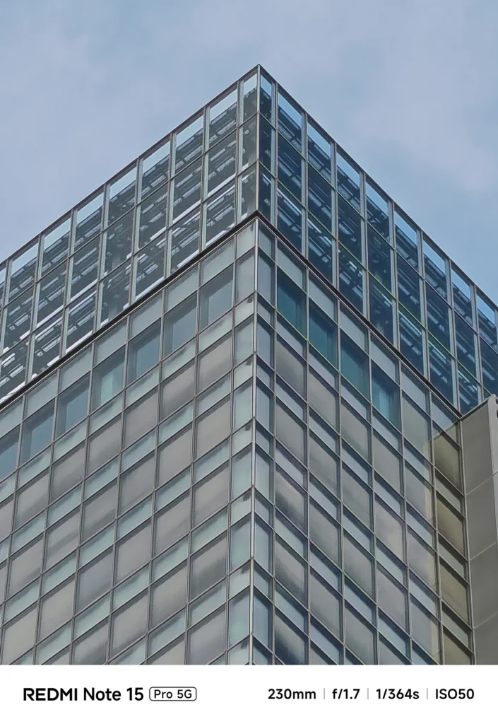 ビル角の鉄骨とガラスの重なりを捉えた望遠接写。Redmi Note 15 Pro 5G(230mm/10倍)で撮影。