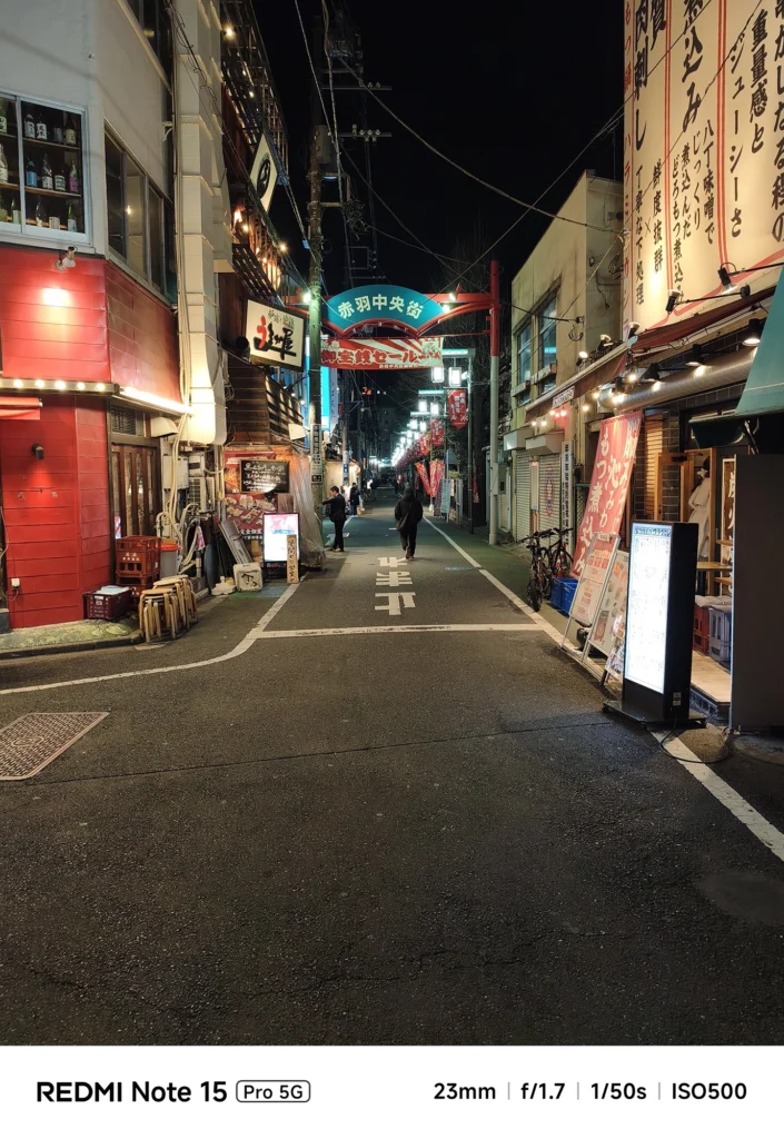 街灯に照らされた夜の「赤羽中央街」商店街の入り口風景。白飛びを抑えた高コントラストな描写。Redmi Note 15 Pro 5G(23mm/夜景モード)で撮影。