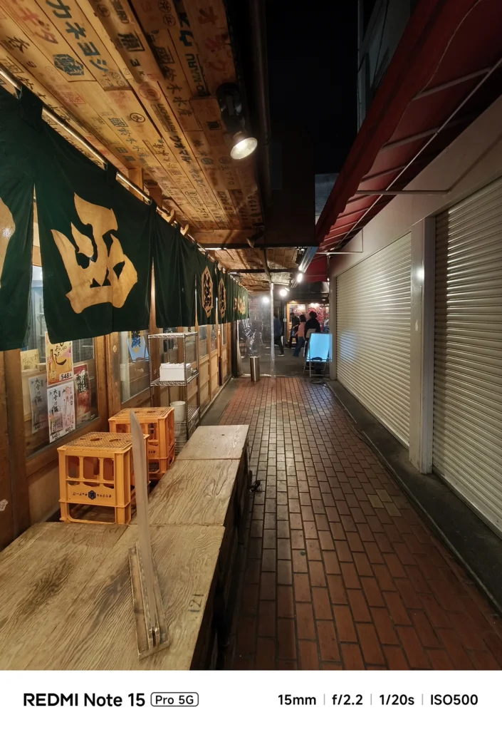閉店後の商店街の路地。並べられたビールケースと暖簾の質感を捉えた夜のスナップ。Redmi Note 15 Pro 5G(15mm/夜景モード)で撮影。