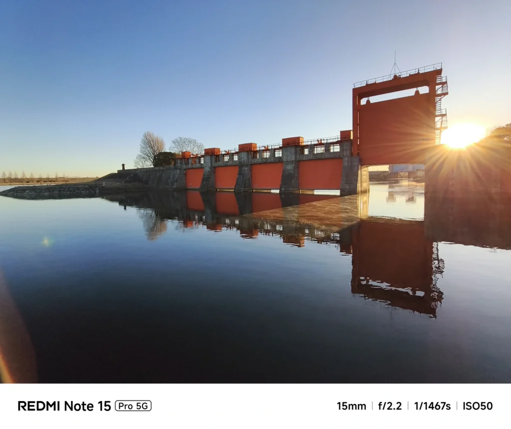 Redmi Note 15 Pro 5G 実機レビュー。旧岩淵水門(赤水門)を背景にした逆光ショット。15mm f/2.2によるダイナミックな光の筋と反射。