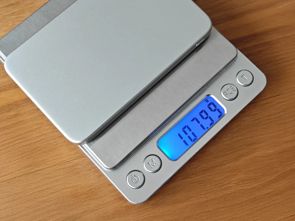 デジタルスケールで超薄型モバイルバッテリーの重さを実測し、107.99gを表示している様子