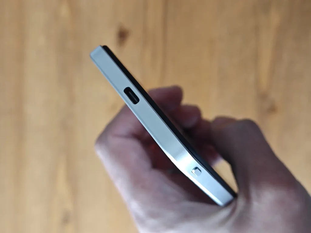 指先で持ったモバイルバッテリーの側面。USB Type-Cポートと電源ボタンの配置がわかる薄型デザイン