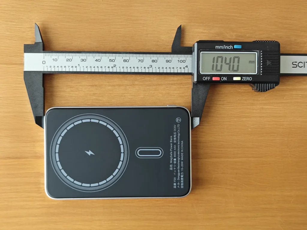 デジタルノギスでMagSafe対応モバイルバッテリーの縦の長さ(104.0mm)を計測する様子