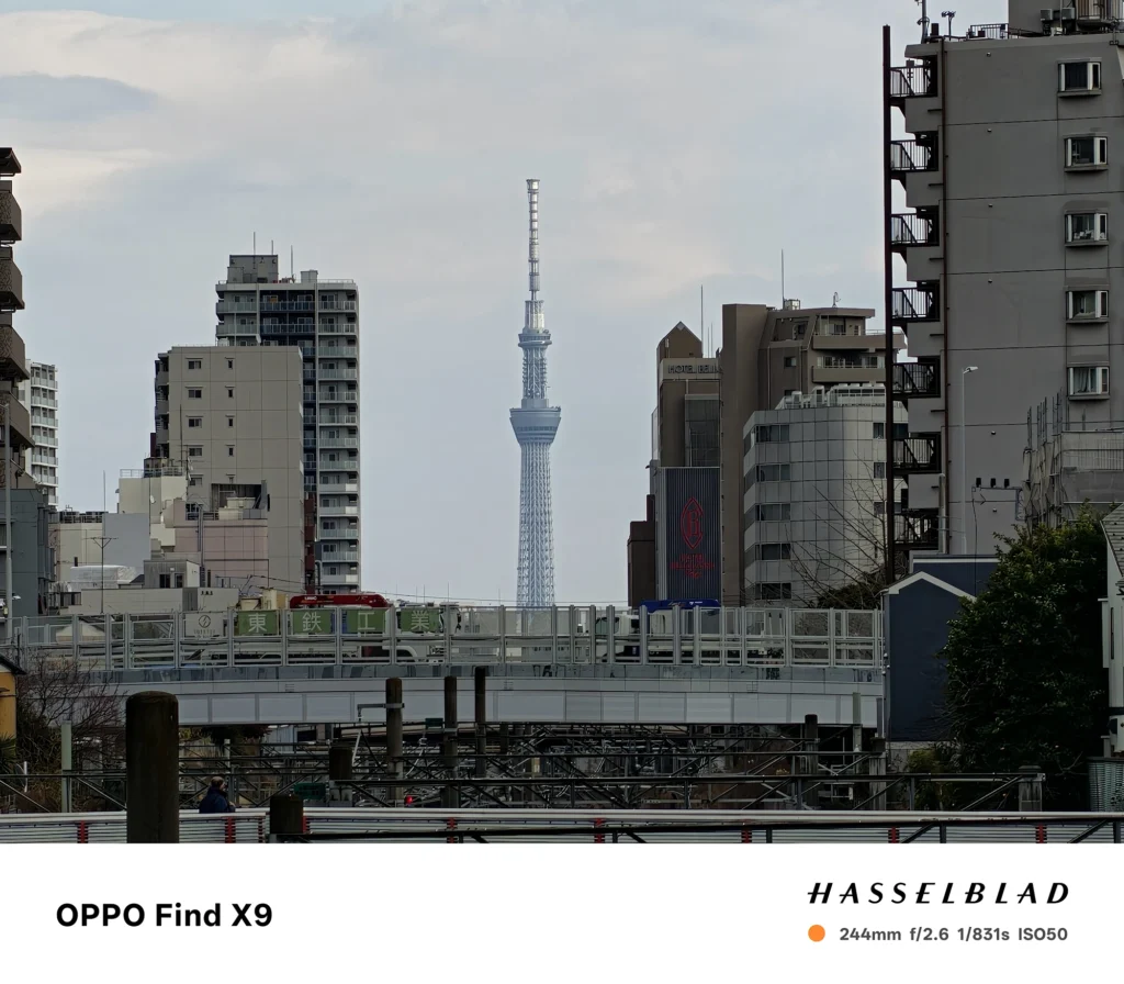 244mm（スカイツリー）: OPPO Find X9で撮影した244mm相当の望遠写真。ビルの谷間に東京スカイツリーを大きく捉えた遠景カット。
