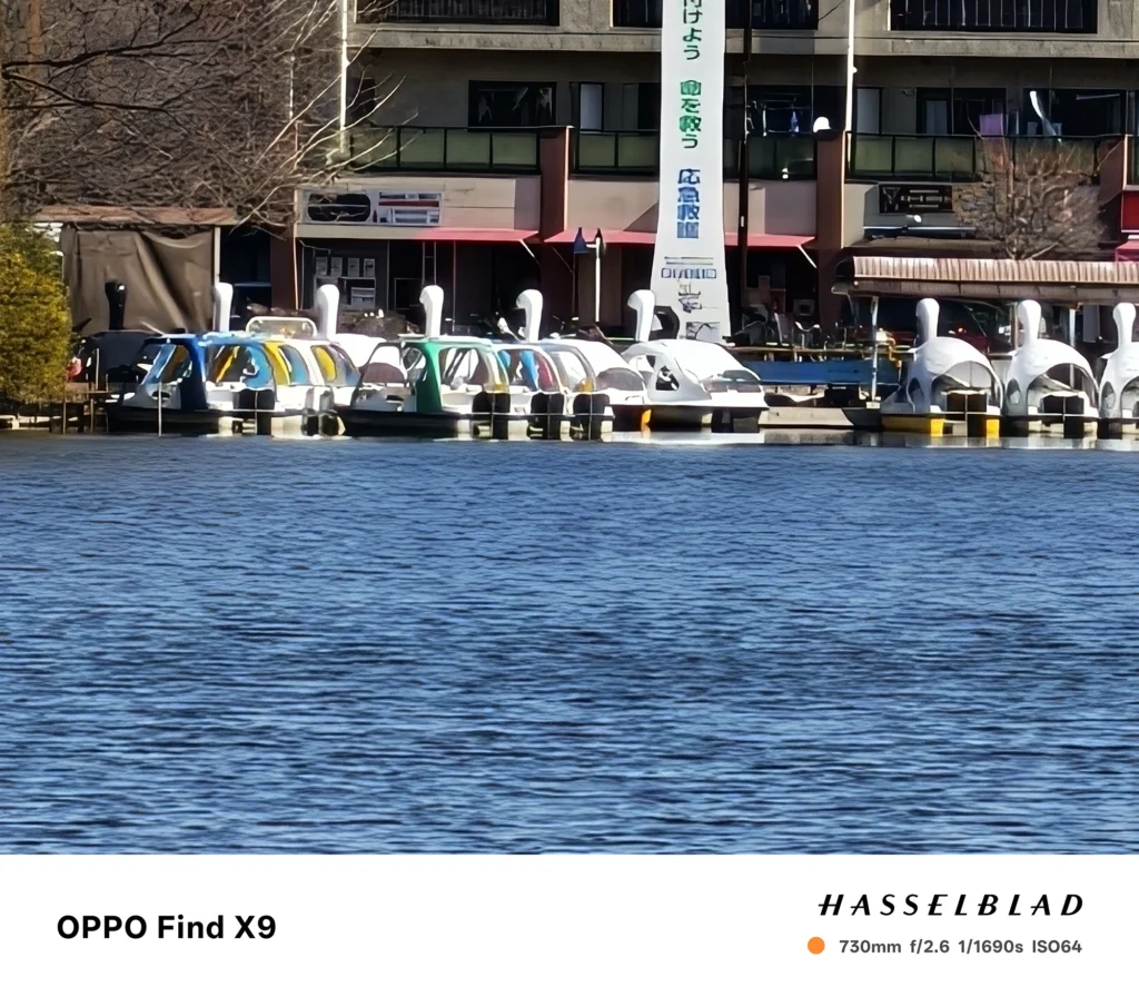 OPPO Find X9 730mmで撮影した湖畔のボート乗り場。白鳥ボートと建物を超望遠で切り取った作例