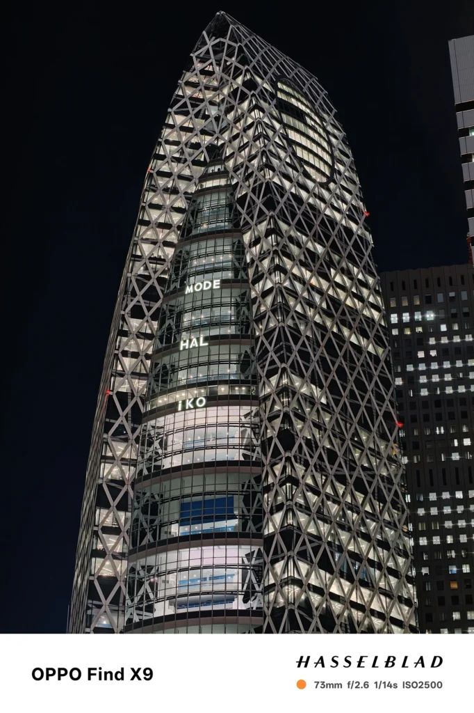 端末名：Find X9／カメラ：望遠／焦点距離：73mm相当／内容：格子状外装の高層ビルを望遠で圧縮し、窓明かりと黒い夜空のコントラストを保ってシャープに引き寄せた夜景