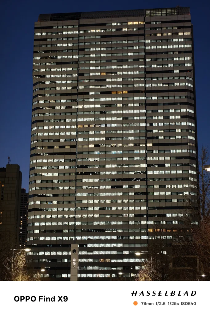 端末名：Find X9／カメラ：望遠／焦点距離：73mm相当／内容：薄暮の空を背景に高層ビルの窓明かりを望遠で圧縮し、規則的な光点の密度を引き寄せて見せた夜景撮影