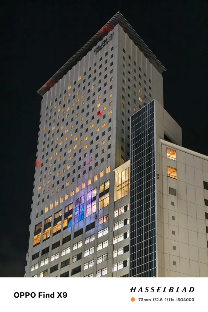 Find X9／カメラ：望遠／焦点距離：73mm相当／内容：高層ビルの窓明かりを望遠で圧縮し、黒い夜空の中に反復する光点を整理して見せた望遠夜景