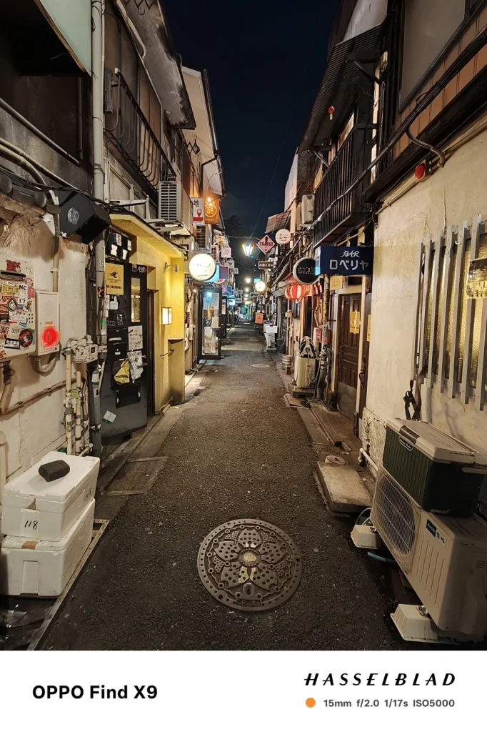 端末名：Find X9／カメラ：超広角／焦点距離：15mm相当／内容：提灯や看板が続く細い通りを奥まで捉え、点在する照明が路面を照らす夜の路地