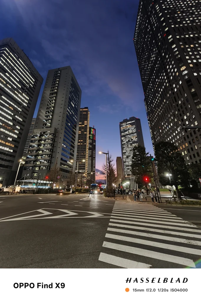 Find X9 (061bdd): 超高層ビル群を仰ぎ見る夜景の15mm超広角ショット。ビルの窓の明かりが白飛びせず、空のグラデーションも滑らか。