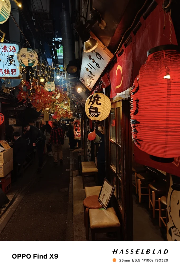 端末名：Find X9／カメラ：メイン（広角）ポートレート／焦点距離：23mm相当／内容：紅葉の装飾と提灯を主題に、店先の灯りを背景ボケで溶かして奥行きを出した夜景ポートレート