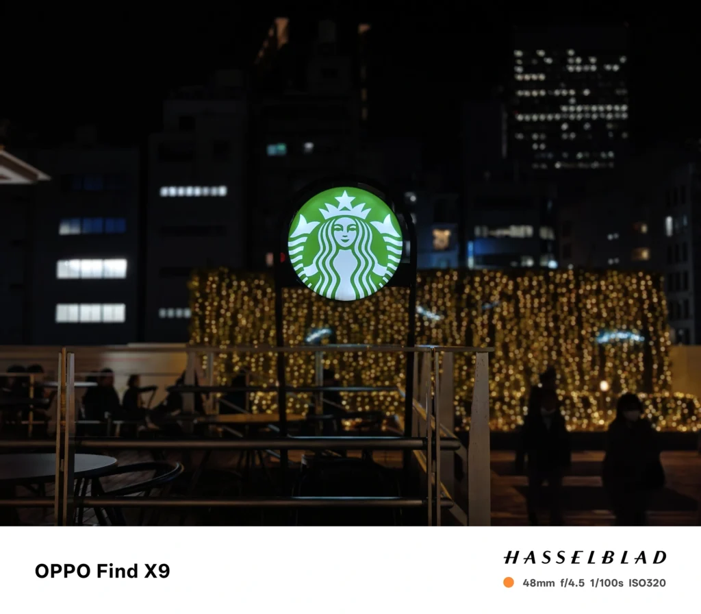 夜景のスターバックス看板を48mmで撮影（OPPO Find X9）。イルミネーションの玉ボケと被写体分離を確認。