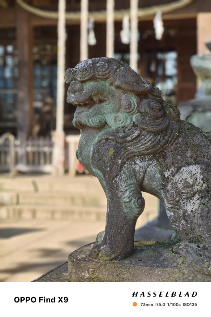 狛犬を73mmポートレートで撮影（OPPO Find X9）。背景を大きくぼかし立体感を強調した作例。