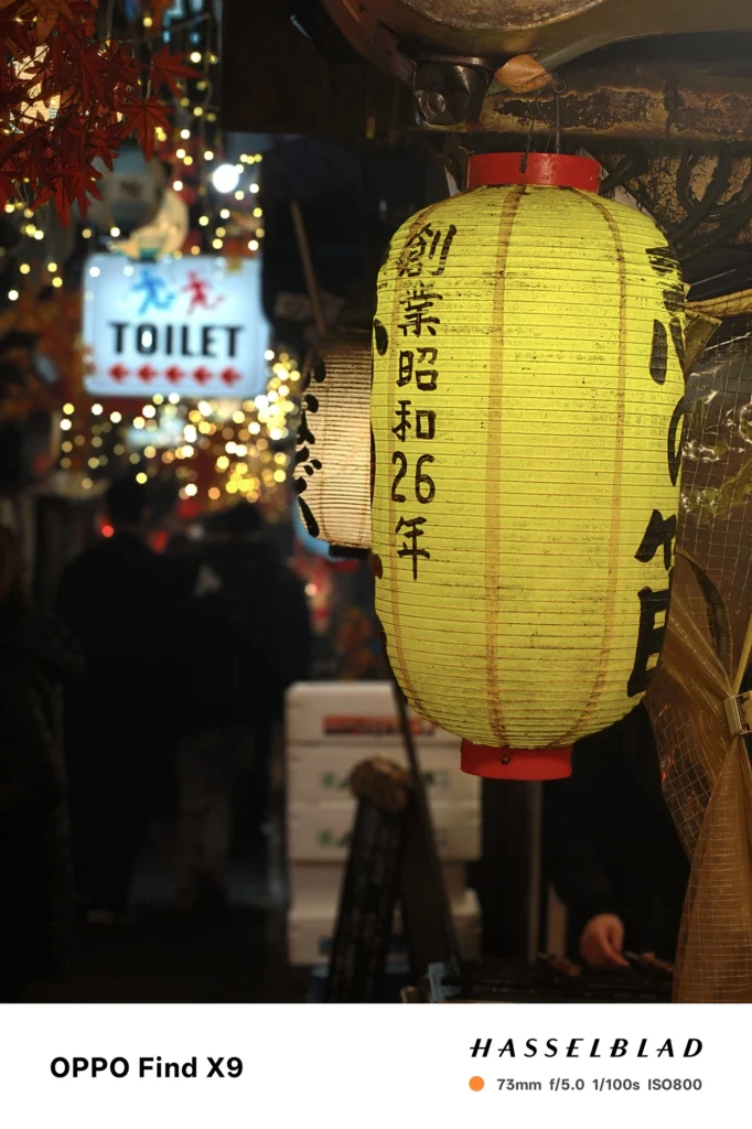 夜の路地で黄色い提灯を73mmポートレート撮影（OPPO Find X9）。発光体の描写と背景ボケを確認。
